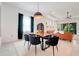 Bright dining area featuring modern light fixture, wood table, and adjacent living area with large windows at 1990 Wallingford Loop, Mount Dora, FL 32757
