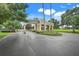 Gated community entrance with mature trees and landscaping creating a welcoming approach to the neighborhood at 1990 Wallingford Loop, Mount Dora, FL 32757