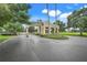 Community entrance featuring a private gate, lush landscaping, and a secure access point at 1990 Wallingford Loop, Mount Dora, FL 32757