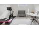 Bright exercise room with a stationary bike, gray couch, and large white desk at 1990 Wallingford Loop, Mount Dora, FL 32757