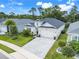 Charming single-story home with a well-manicured lawn, a two-car garage, and tropical landscaping at 1990 Wallingford Loop, Mount Dora, FL 32757