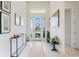 The bright foyer has high ceilings and neutral decor, as well as tile flooring and elegant furnishings at 1990 Wallingford Loop, Mount Dora, FL 32757