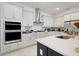 Bright kitchen boasts white cabinets, stainless steel appliances and a stylish island with a sink at 1990 Wallingford Loop, Mount Dora, FL 32757