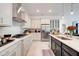 Spacious kitchen featuring white cabinets, stainless steel appliances, and a large island at 1990 Wallingford Loop, Mount Dora, FL 32757