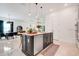 Modern kitchen featuring an island with seating, stainless steel appliances, and open dining area at 1990 Wallingford Loop, Mount Dora, FL 32757