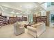 Well-stocked library with comfortable seating, built-in bookshelves, and elegant chandelier lighting at 1990 Wallingford Loop, Mount Dora, FL 32757