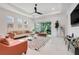 Spacious living room has lots of light, neutral walls, a ceiling fan, and a modern geometric rug at 1990 Wallingford Loop, Mount Dora, FL 32757