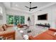 Open living room with white walls, modern decor, a tray ceiling, and large windows at 1990 Wallingford Loop, Mount Dora, FL 32757