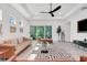 Bright, open living room showcases neutral decor, a ceiling fan, tile flooring, and a contemporary rug at 1990 Wallingford Loop, Mount Dora, FL 32757