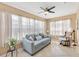 Bright and airy living room with large windows, a ceiling fan, and comfortable seating at 2017 Palo Alto Ave, The Villages, FL 32159