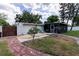 Well-kept backyard featuring a mix of grass and gravel, a stone pathway, and a screened-in patio at 212 Blossom Ln, Winter Park, FL 32789