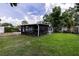 View of a lush backyard featuring a screened-in patio and well-maintained lawn at 212 Blossom Ln, Winter Park, FL 32789
