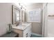 Bright bathroom with granite countertop vanity, stylish mirrors, and shuttered window at 212 Blossom Ln, Winter Park, FL 32789