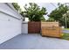 Exterior view of a home featuring a white garage door, a wooden fence, and a well-maintained gray driveway at 212 Blossom Ln, Winter Park, FL 32789