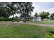Expansive front yard with a red brick driveway leading to a charming single-story home surrounded by mature trees at 212 Blossom Ln, Winter Park, FL 32789