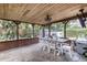 Covered outdoor dining area with long table and seating for Gathering gathering, TV, and cooler at 212 Blossom Ln, Winter Park, FL 32789