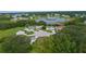 Expansive aerial view of homes in a cul-de-sac, surrounded by trees and a tranquil pond at 24954 Navel Ave, Leesburg, FL 34748