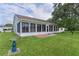 Spacious backyard featuring a screened-in patio area and lush green lawn at 24954 Navel Ave, Leesburg, FL 34748