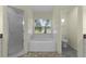 Well-lit bathroom featuring a soaking tub, a separate shower, and neutral-toned tile flooring at 24954 Navel Ave, Leesburg, FL 34748