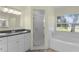 Bright bathroom with a granite countertop vanity, a bath tub, and tile flooring at 24954 Navel Ave, Leesburg, FL 34748
