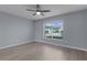 Bedroom with hardwood floors, a ceiling fan, and a large window at 24954 Navel Ave, Leesburg, FL 34748