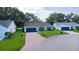 Charming single-story home with a brick driveway, well-maintained lawn, and blue trim accents at 24954 Navel Ave, Leesburg, FL 34748