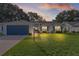 Charming home exterior with well-manicured lawn, brick driveway, and tasteful landscaping at 24954 Navel Ave, Leesburg, FL 34748