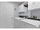 Functional laundry room with a washer, a dryer, storage cabinets, and a neutral color scheme at 24954 Navel Ave, Leesburg, FL 34748