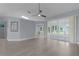 Spacious living room with laminate flooring, modern lighting, and sliding glass doors to the sunroom at 24954 Navel Ave, Leesburg, FL 34748