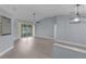 Spacious living room with gray walls, light hardwood floors, and views of the screened-in porch at 24954 Navel Ave, Leesburg, FL 34748