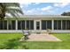 Back porch and yard area features seating area, lush grass, well-manicured shrubbery and sunny skies at 26034 Oakmount Dr, Leesburg, FL 34748