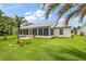 A back yard that features lush lawn, palm trees, and a covered lanai perfect for outdoor enjoyment at 26034 Oakmount Dr, Leesburg, FL 34748