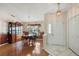 An open dining room displays hardwood floors, chandelier, and front door access at 26034 Oakmount Dr, Leesburg, FL 34748