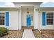 Close-up of the front entrance featuring a blue door with white trim and decorative shutters at 26034 Oakmount Dr, Leesburg, FL 34748