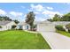 Charming home featuring a well-maintained lawn, an attached two-car garage, and inviting curb appeal at 26034 Oakmount Dr, Leesburg, FL 34748