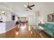 A living room shows wood flooring with a dining room and turquoise couch at 26034 Oakmount Dr, Leesburg, FL 34748