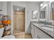 Bathroom featuring tiled walk-in shower and double sinks with granite counters at 2743 Nattie Ct, Orlando, FL 32826