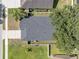 Bird's-eye view of a home's roof with palm trees and large trees in the front and back yards at 2849 Doe Run Trl, Orange City, FL 32763