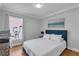 Bright bedroom features a large window, hardwood floors, and a bed with a blue headboard at 2849 Doe Run Trl, Orange City, FL 32763