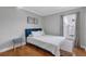 This bedroom features hardwood floors, a window, a bed with white comforter and blue headboard at 2849 Doe Run Trl, Orange City, FL 32763