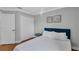 This bedroom features hardwood floors, a closet, a bed with a white comforter and blue headboard at 2849 Doe Run Trl, Orange City, FL 32763