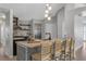 Modern kitchen island with seating, pendant lighting, stylish decor, and stainless steel appliances at 2849 Doe Run Trl, Orange City, FL 32763