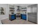 Modern kitchen featuring stainless steel appliances, blue cabinets, open shelves and a stylish range hood at 2849 Doe Run Trl, Orange City, FL 32763