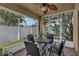 Comfortable screened porch featuring a table, chairs, and a ceiling fan at 2849 Doe Run Trl, Orange City, FL 32763