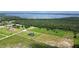 Expansive aerial view of the property with sprawling green fields and scenic lake in the distance at 29222 Can Do Ln, Tavares, FL 32778