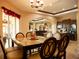 Dining room with a glass-top table, upholstered chairs, and view into the living room at 29222 Can Do Ln, Tavares, FL 32778