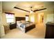 An expansive primary bedroom boasts a tray ceiling, carpeting, and adjoins to the main bathroom at 29222 Can Do Ln, Tavares, FL 32778