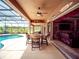 Inviting covered patio with dining area overlooking sparkling pool and lush green fields at 29222 Can Do Ln, Tavares, FL 32778