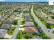 Wide angle aerial shot of a neighborhood displaying houses and roadways, set on beautiful landscaping at 2994 Adrienne Way, The Villages, FL 32163
