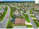 Overhead view of a neighborhood featuring lush landscaping, houses, and a community road at 2994 Adrienne Way, The Villages, FL 32163